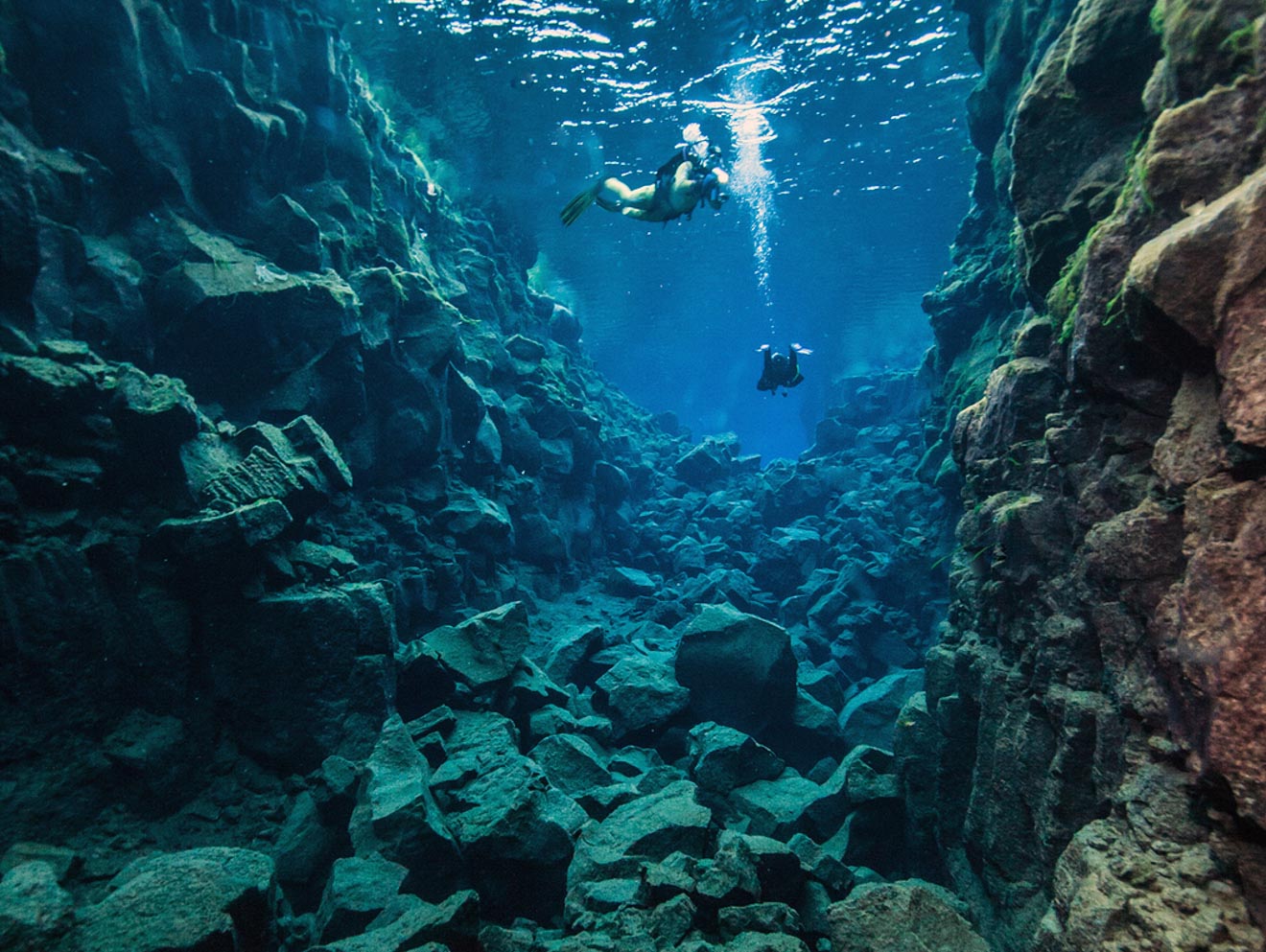 a group of people swimming in a cave