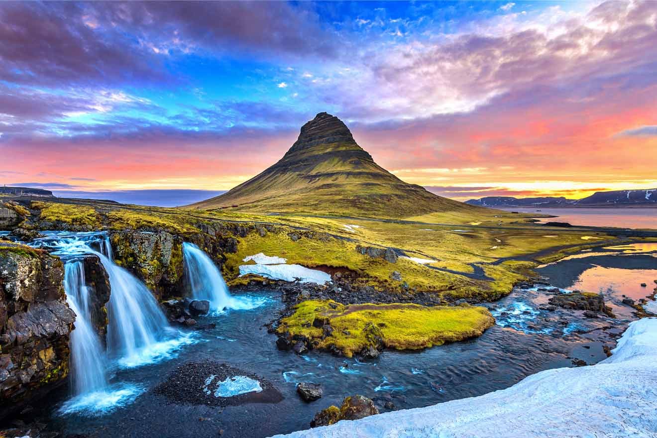 The iconic Kirkjufell mountain bathed in the glow of a sunset with waterfalls in the foreground and a picturesque landscape in Snaefellsnes Peninsula, Iceland