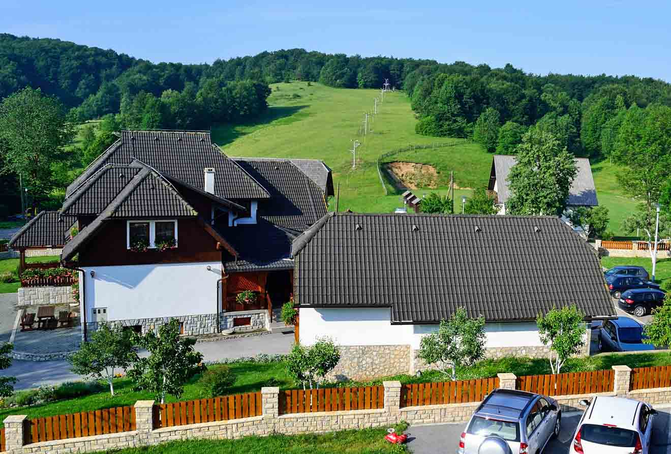 View of a rural resort with modern houses and a ski slope in the background