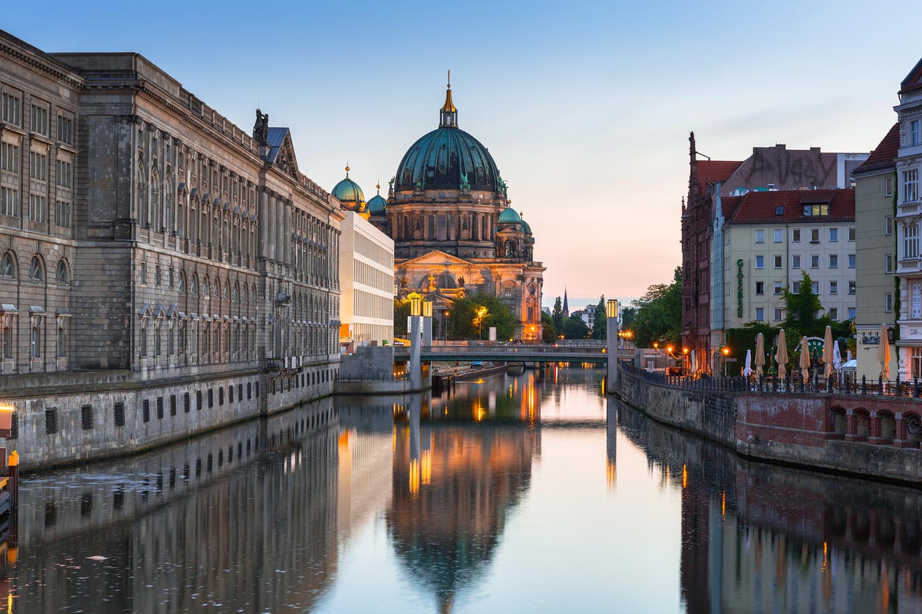 View of a river at dusk with a bridge and a cathedral in the background