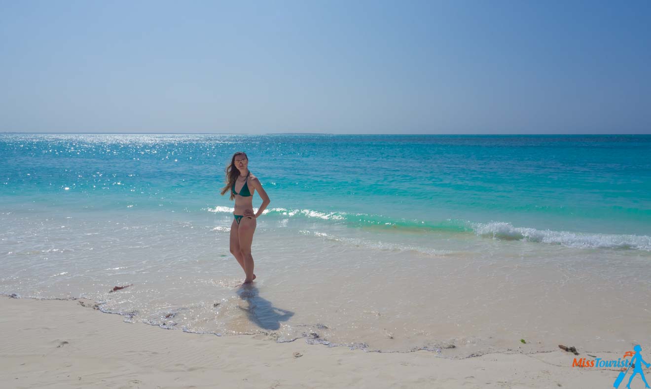 Yulia in a bikini standing on the sandy Nungwi beach in Zanzibar