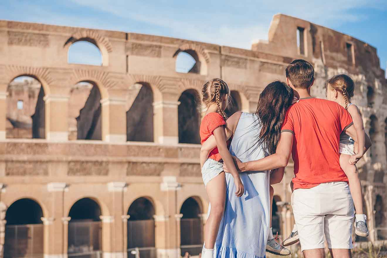 A family is standing in front of the colosseum in rome.