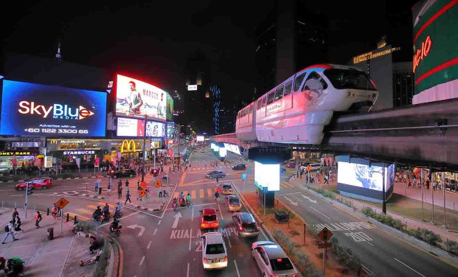 Busy street and restaurants at night in Bukit Bintang where to stay in Kuala Lumpur for foodies