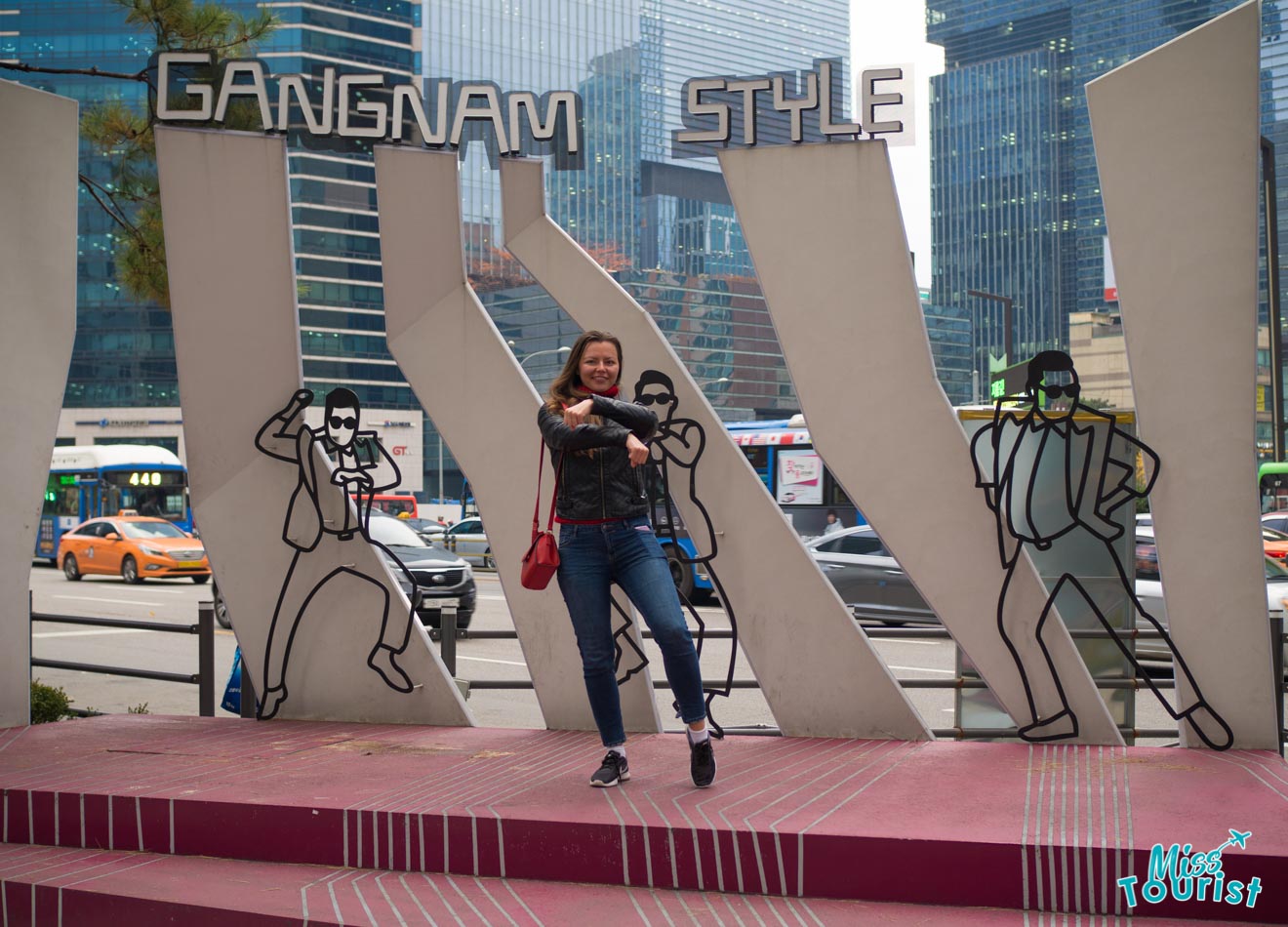 Yulia Saf, the author of the post, posing for a picture in front of a monument dedicated to Gangnam Style