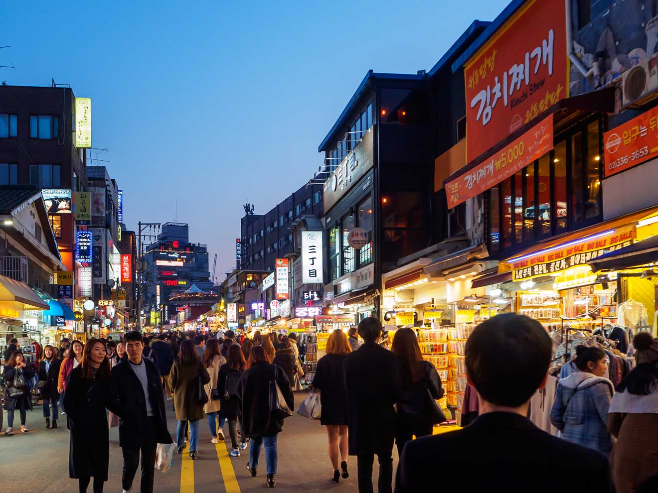 A crowded street with many people walking around in Hongdae neighborhood Seoul South Korea
