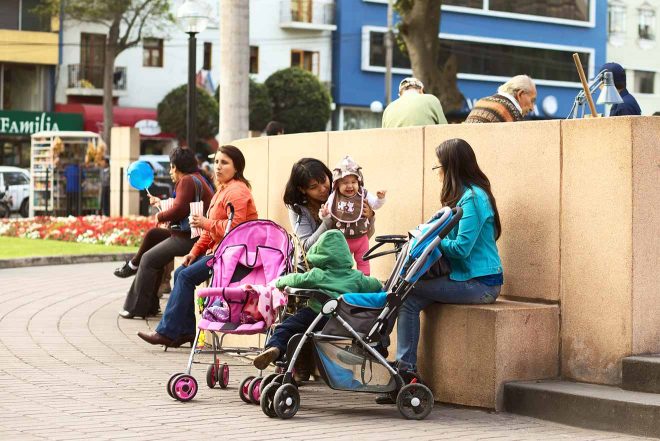 two mothers with babies in strollers siting and talking in Lima