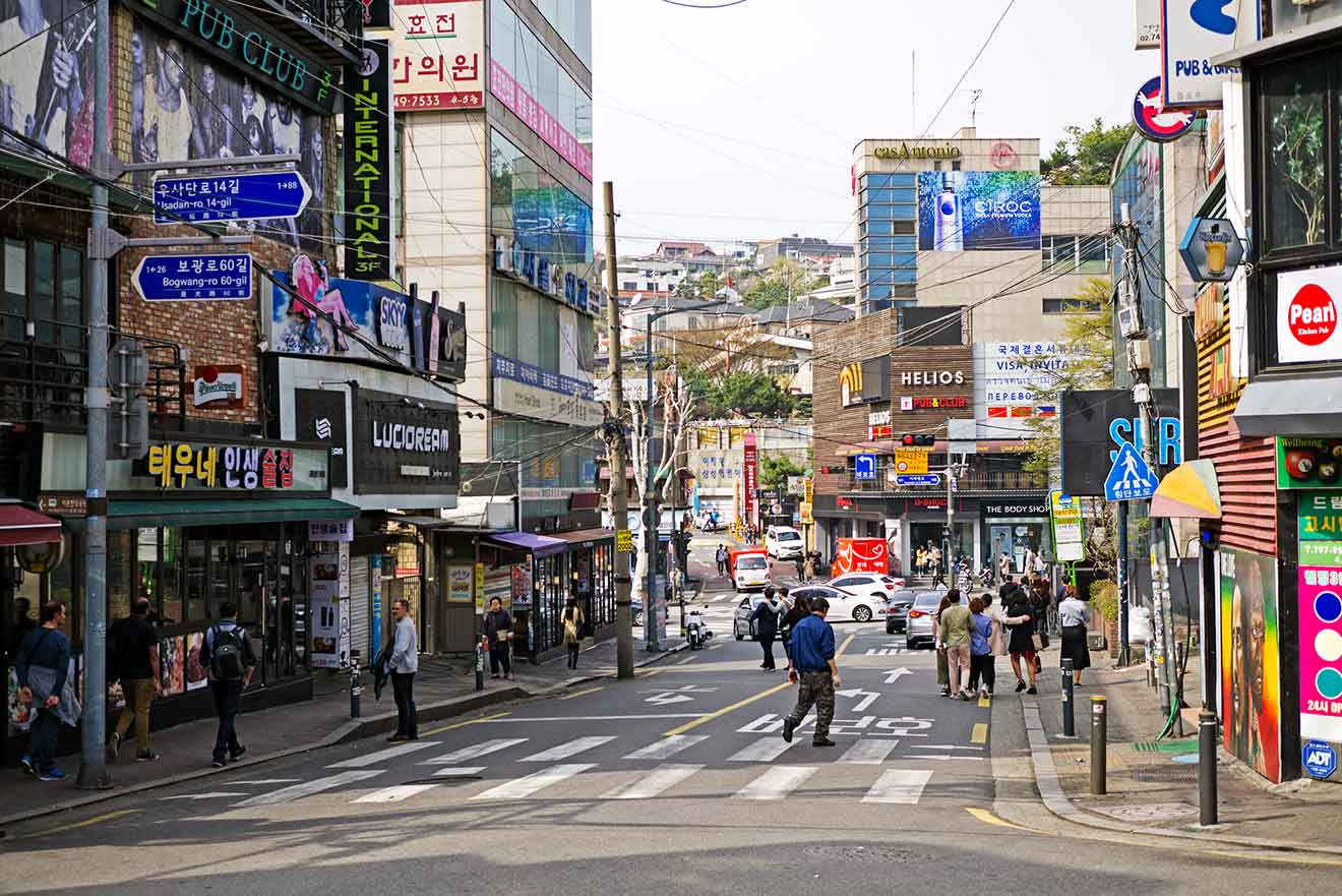 A street in a city with many shops and restaurants and a lot of people walking down it in Seoul