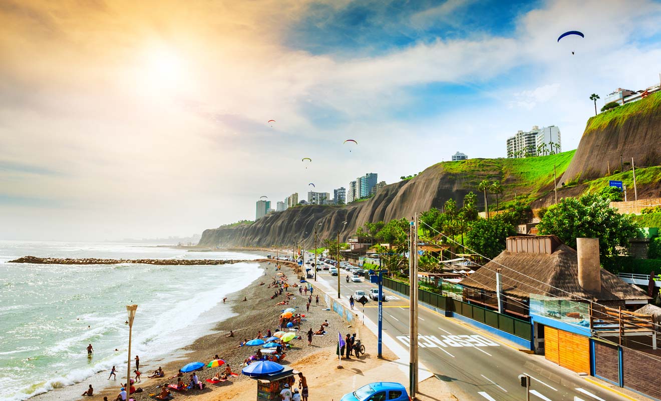 A beach with people on it and a cliff in the background. in Miraflores in Lima