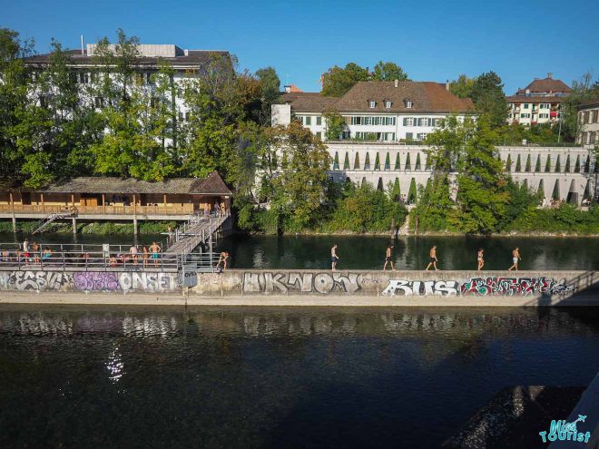 people on the side of river zurich