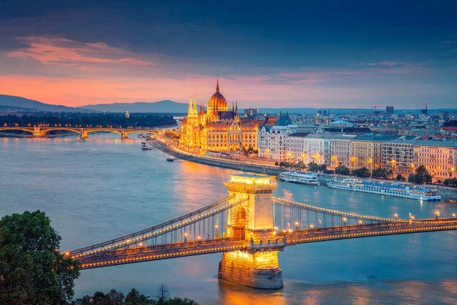 View of the lit-up Chain Bridge over the river Danube with the Parliament in the background in Budapest, at night