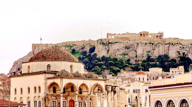 Classic architecture in Athens with the Acropolis in the background, illustrating the historic blend of different eras in one frame.