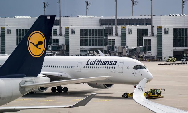 Lufthansa planes parked on the tarmac at an airport.