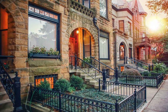 Sunset view of a charming residential street in Chicago, featuring historic brownstone houses with intricate facades