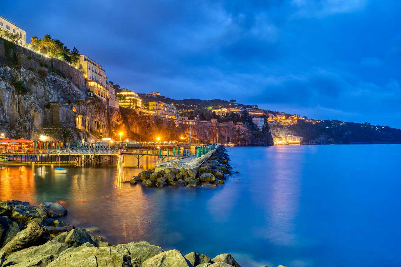 A board walk in the water with buildings the town of Sorrento on the Amalfi Coast in Italy at dusk