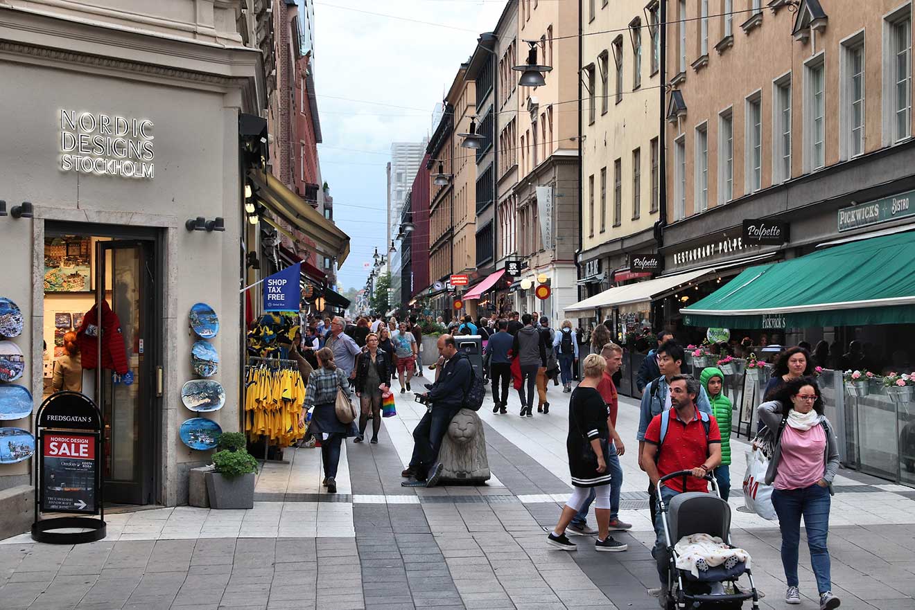 Busy shopping street in Stockholm with pedestrians, shops, and city life
