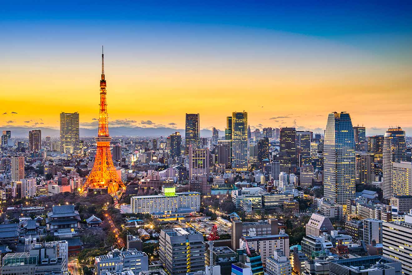 Panoramic twilight view of Tokyo cityscape with the iconic Tokyo Tower lit in orange amidst the skyscrapers