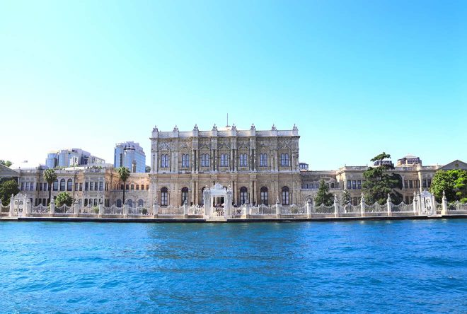 The ornate Dolmabahce Palace in Istanbul, Turkey, viewed from across the Bosphorus with clear blue waters in the foreground