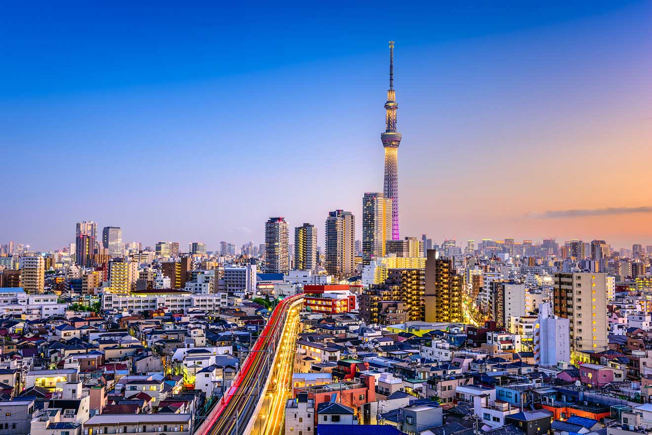 Dusk skyline of Tokyo featuring the Tokyo Skytree amid city buildings with lights starting to illuminate the evening