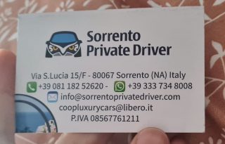 A person holding a business card for a Sorrento private driver.