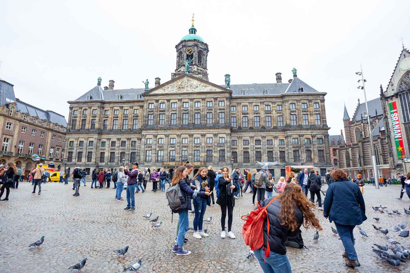 A bustling scene in front of the Royal Palace Amsterdam with tourists mingling and taking photos, pigeons scattered on the cobblestone square, all set against the backdrop of the historic and grand façade of the palace