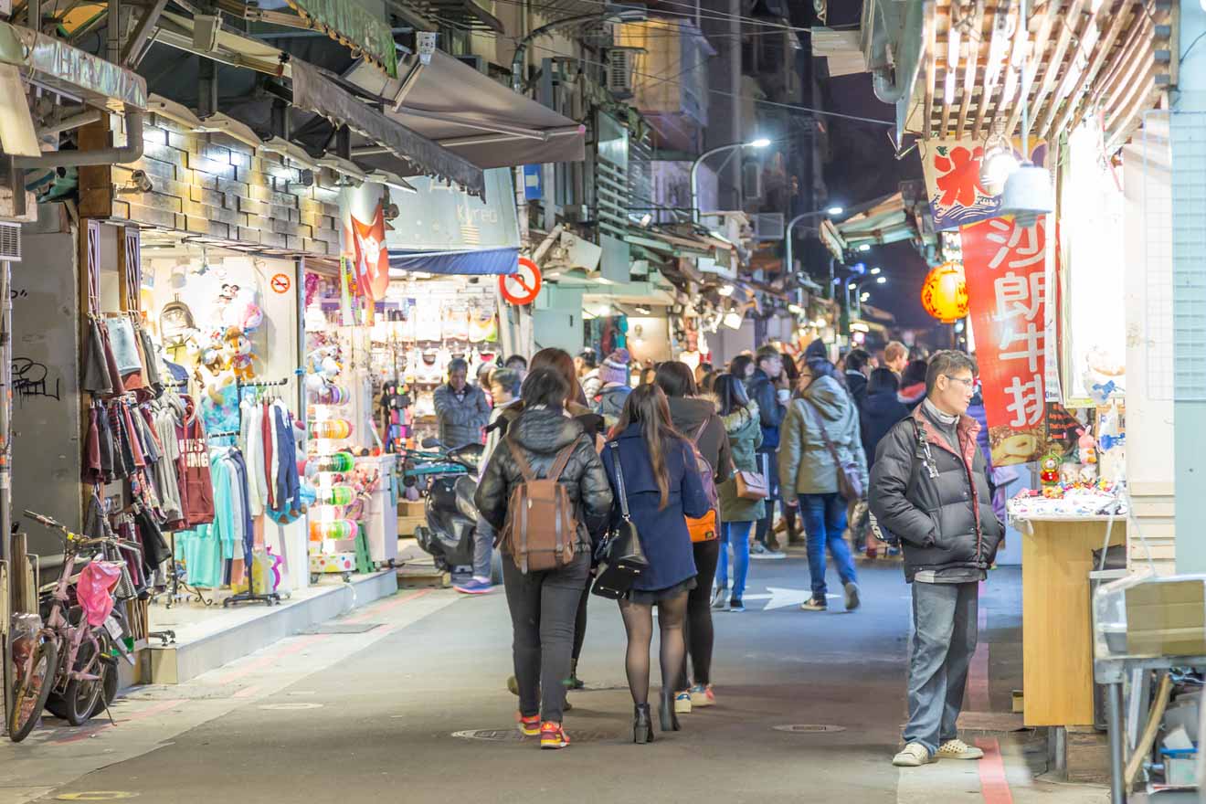 Night view of a crowded market alley in Taipei with shops and shoppers