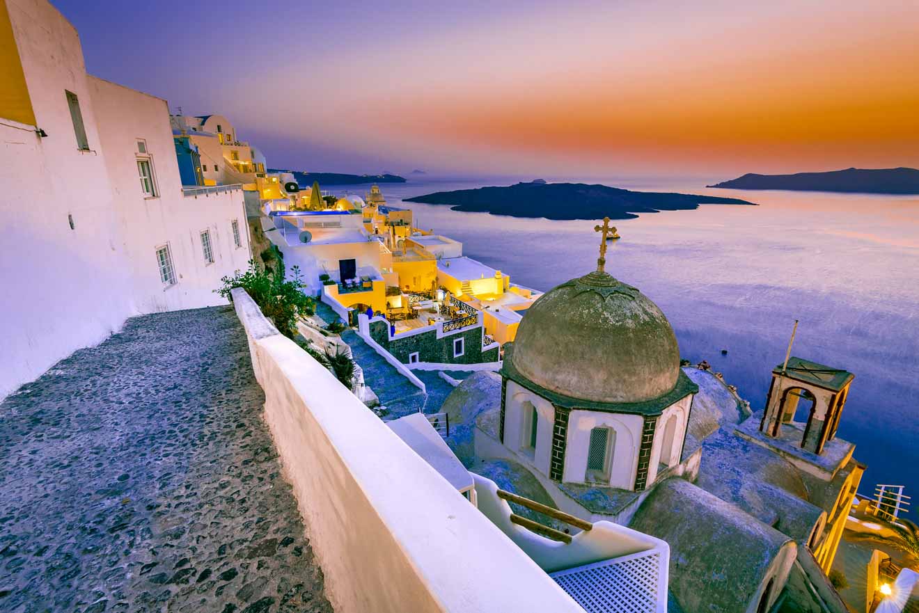 Twilight over Santorini's white buildings and blue domes.