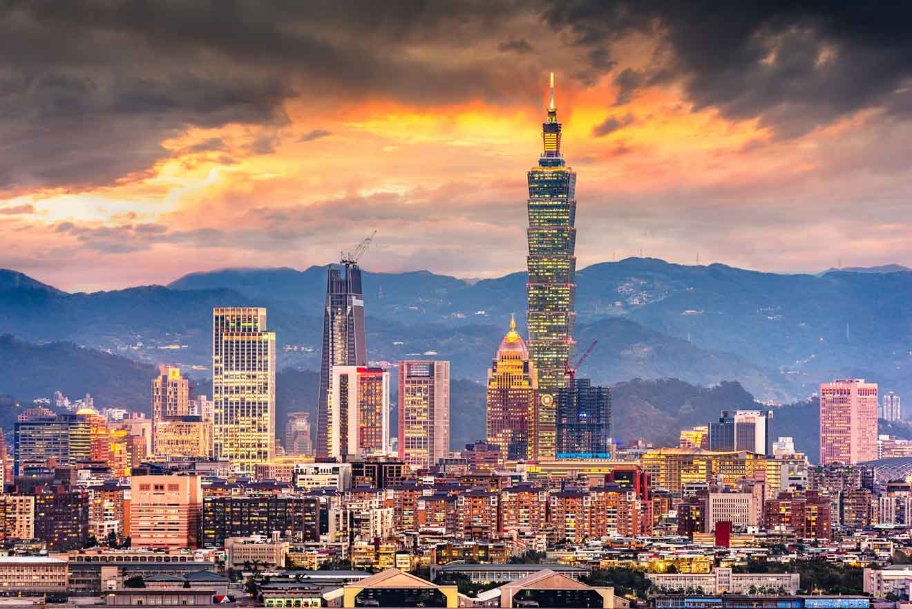 Dramatic sunset view of the Taipei skyline with Taipei 101 standing prominently against the mountainous backdrop