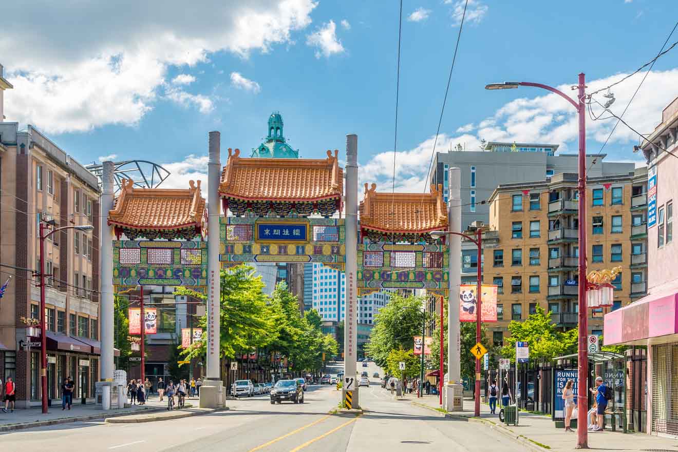 The historic Chinatown Millennium Gate under a clear blue sky on a bustling street in Vancouver