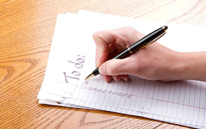 person filling out a to do list