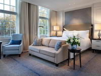 a luxurious hotel room with a comfortable seating area