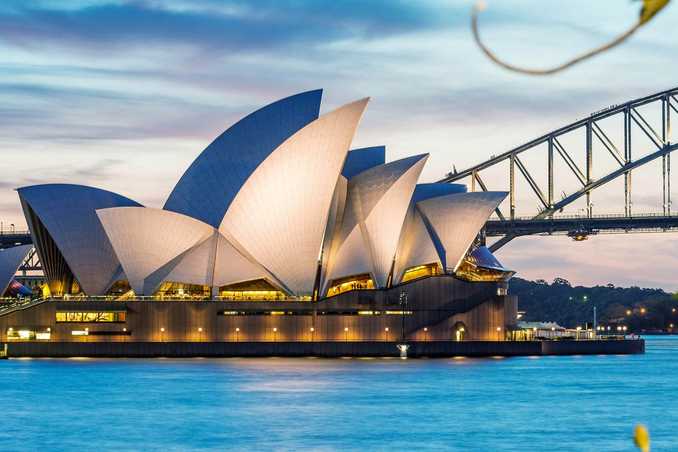 the sydney opera house is lit up at night