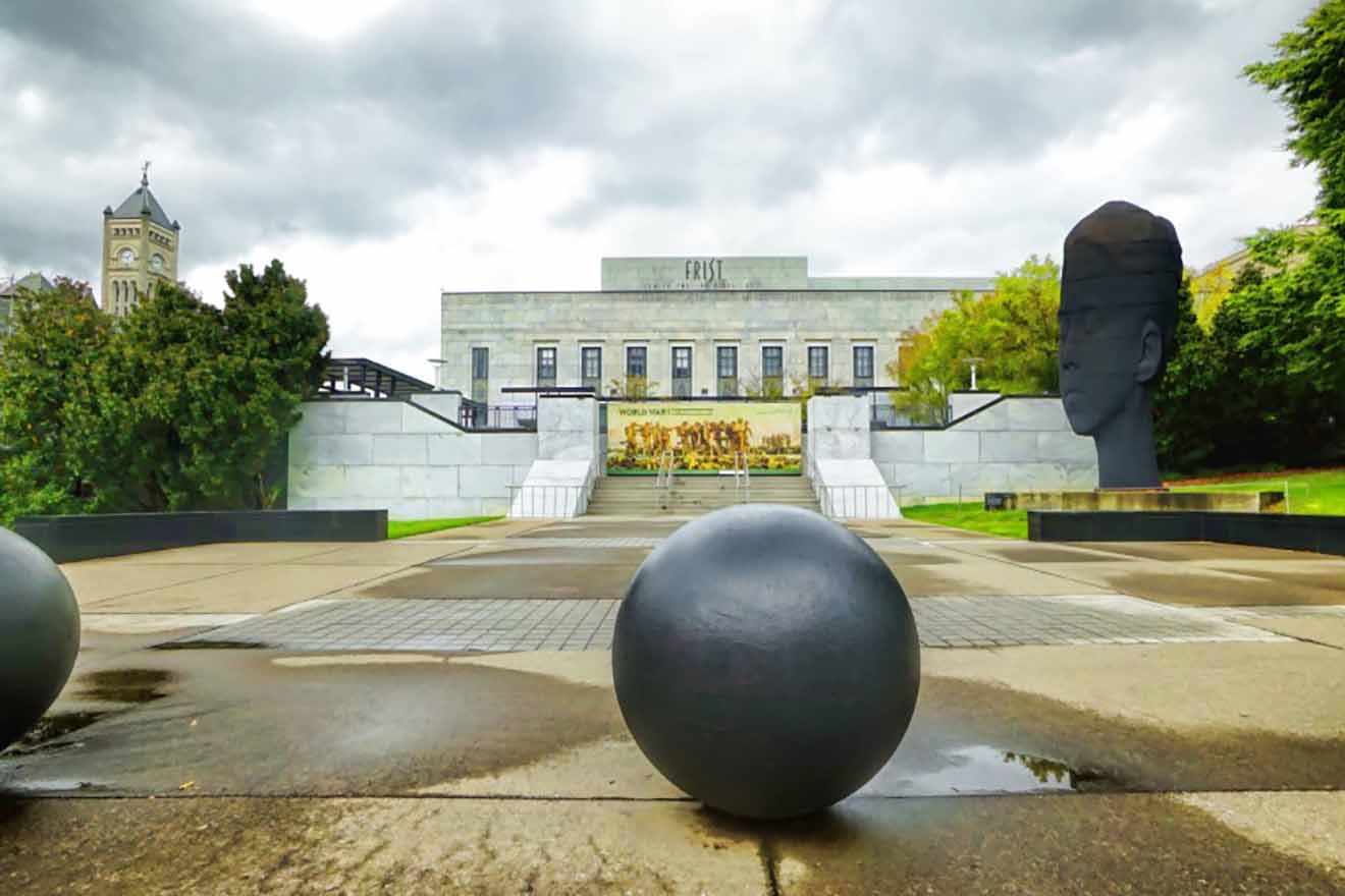 Wide-angle view of the Frist Art Museum in Nashville, showing its classic architecture and an outdoor art installation under an overcast sky