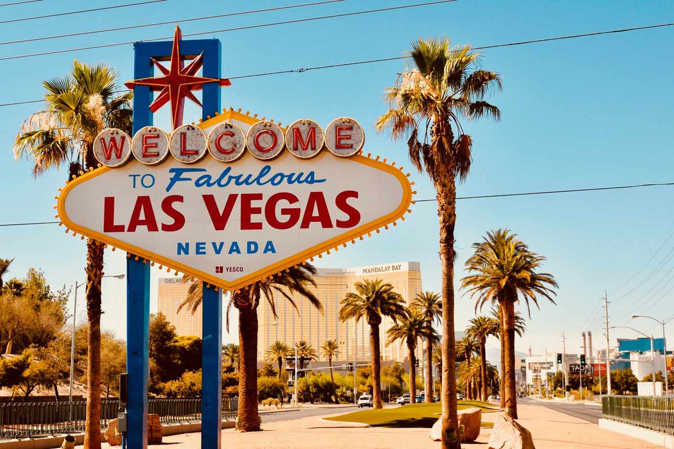 "Iconic 'Welcome to Fabulous Las Vegas' sign with palm trees and a clear blue sky in the background