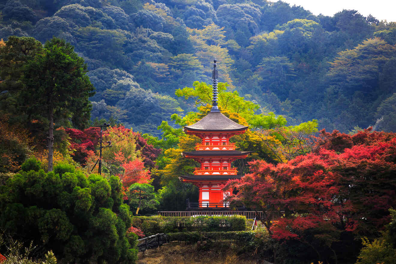 A vibrant autumn scene with a bright red pagoda nestled among trees with multicolored leaves, showcasing Japan's fall beauty.