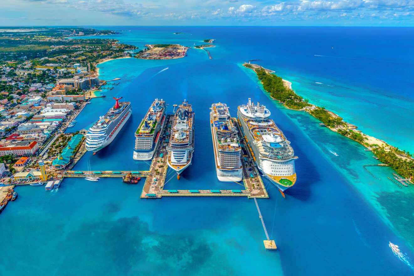 Aerial view of multiple cruise ships docked at a vibrant port in Nassau with crystal-clear blue waters and a bustling coastal cityscape in the background.