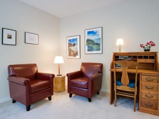 Cozy corner of a living room with two leather armchairs and framed pictures on the wall