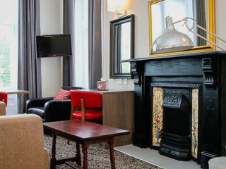 Elegant sitting area with a classic fireplace and eclectic furnishings