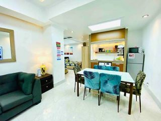 Modern, open-concept kitchen and dining space with clean white aesthetics, a marble countertop, and contemporary furniture