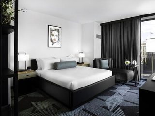 Modern hotel room interior with minimalist decor and a king-sized bed