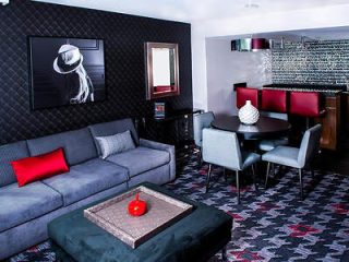 Chic living area inside a hotel suite featuring a gray sectional sofa 