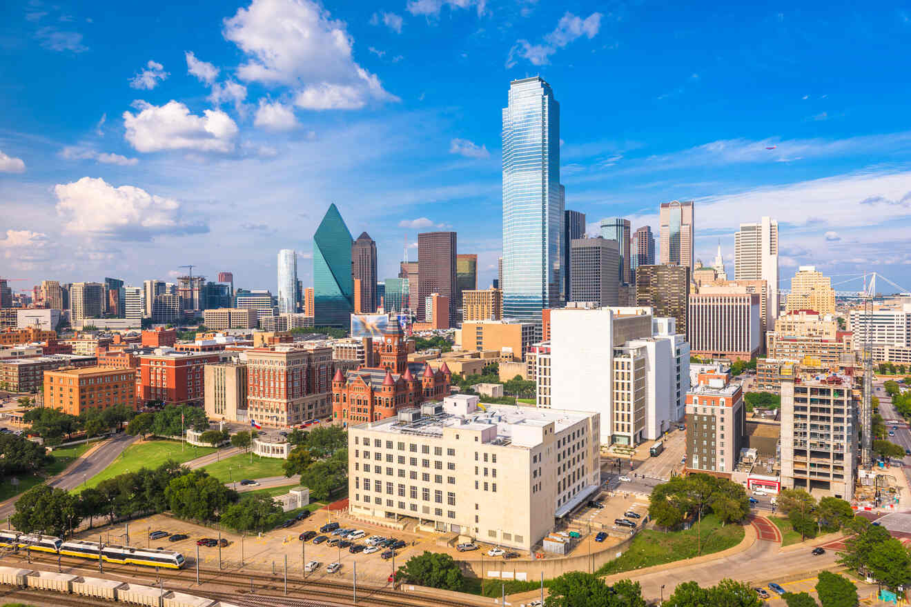 Panoramic view of Dallas skyline with prominent skyscrapers under a clear blue sky, showcasing urban growth and architecture.
