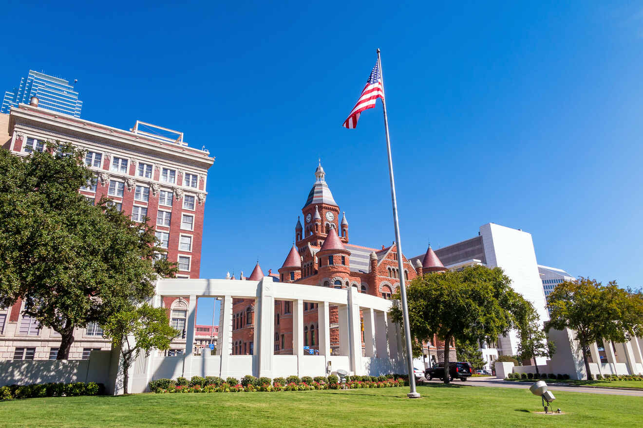 Dallas County Historical Plaza with the American flag flying high near the Old Red Museum, symbolizing Texas heritage and history.
