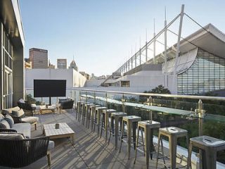 Rooftop patio overlooking Pittsburgh with modern outdoor furniture and a view of the city skyline