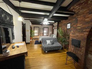 A room with brick walls and a bed in it.