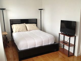 A small bedroom with a bed and a tv.