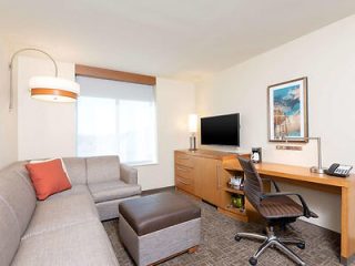 Hotel living area with a comfy L-shaped couch and wooden furniture