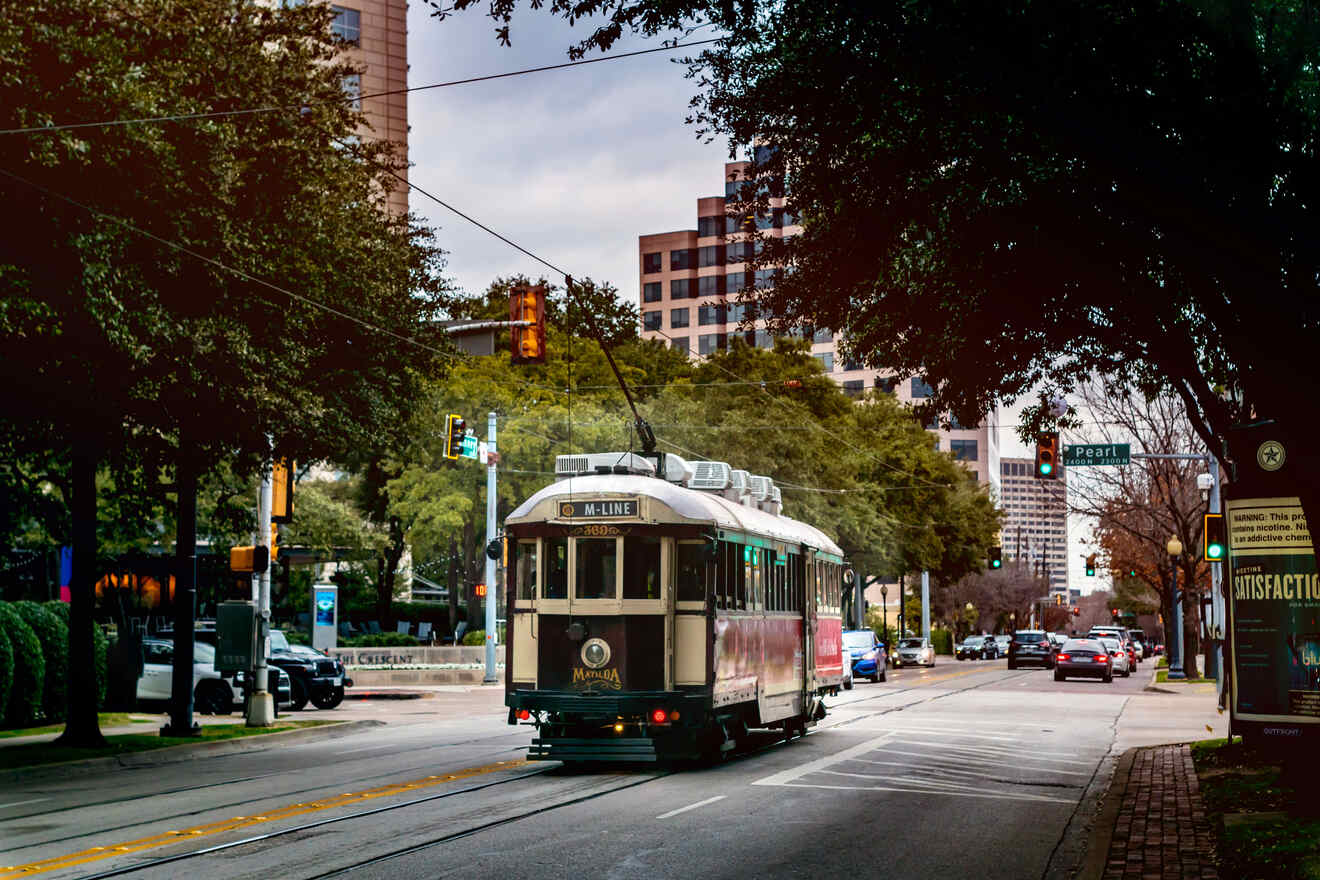 Vintage-style trolley car on Dallas's M-Line against a backdrop of modern city streets, blending history with urban living.
