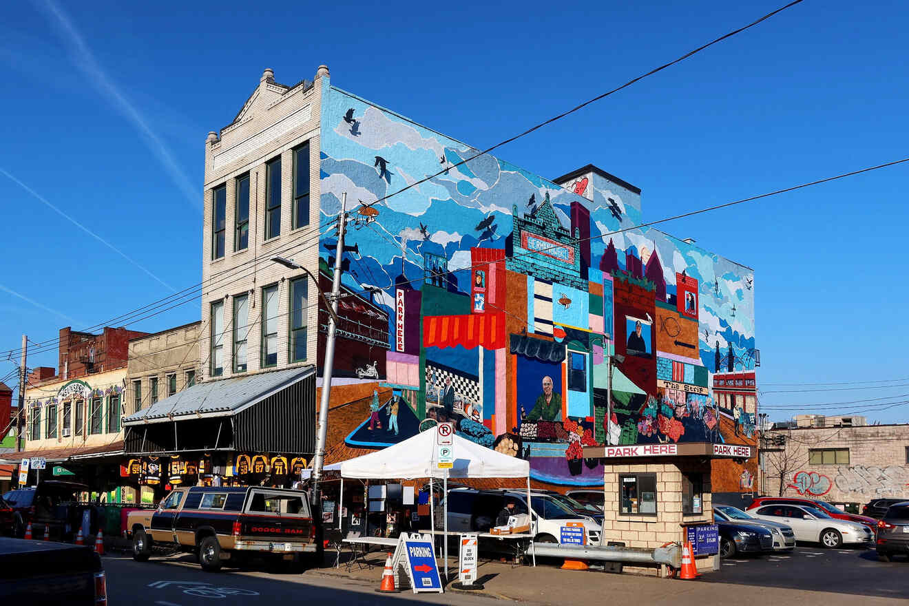 Colorful mural on the side of a building in Pittsburgh depicting various city scenes and activities