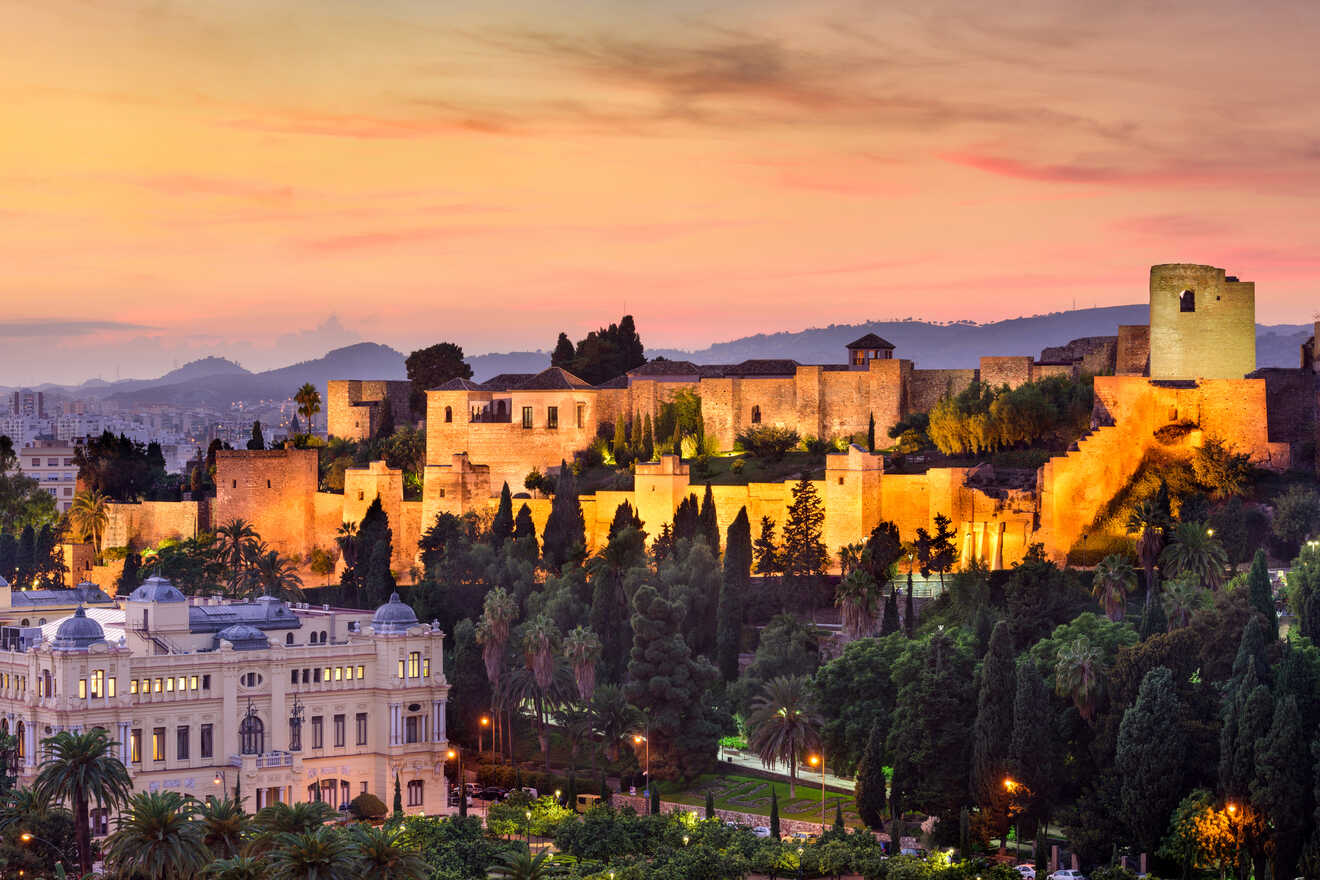 Majestic sunset view of an ancient fortress with illuminated walls, towering over a cityscape surrounded by lush greenery and a soft, glowing sky