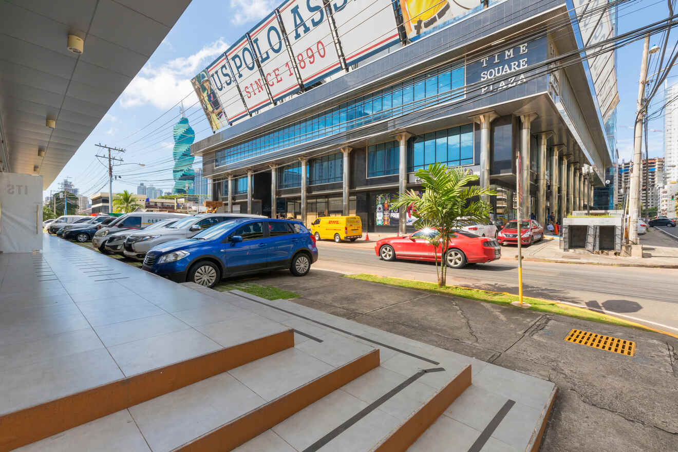 Urban street view outside the Time Square Plaza in Panama with parked cars, modern buildings, and a large billboard for U.S. Polo Assn